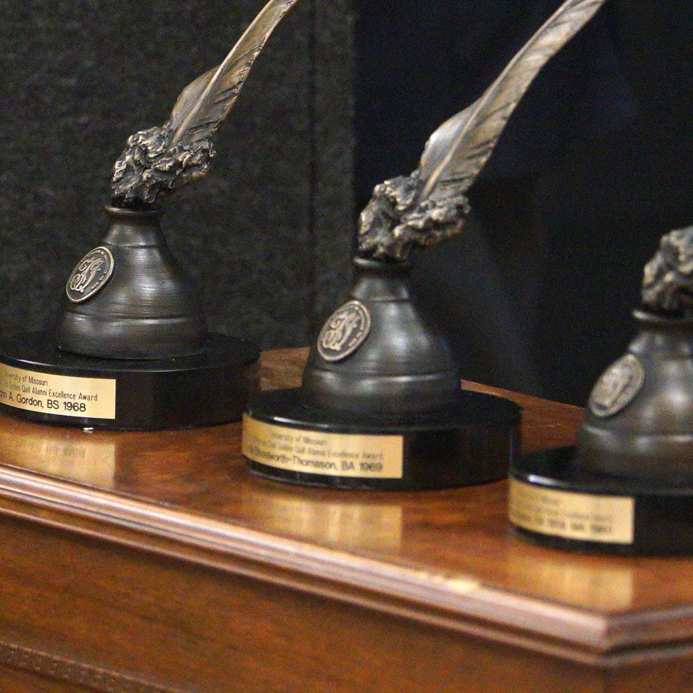 Gold Quill awards placed on a table.