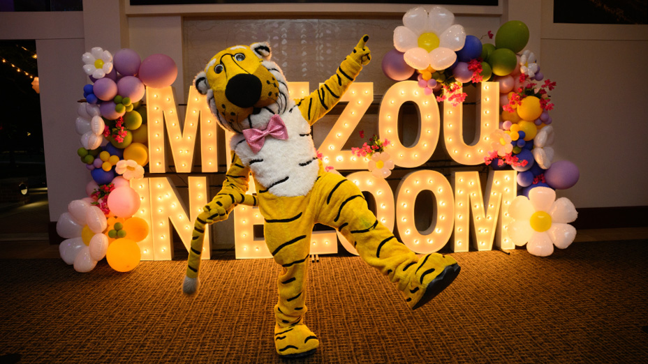 Truman the Tiger in front of Mizzou in Bloom sign